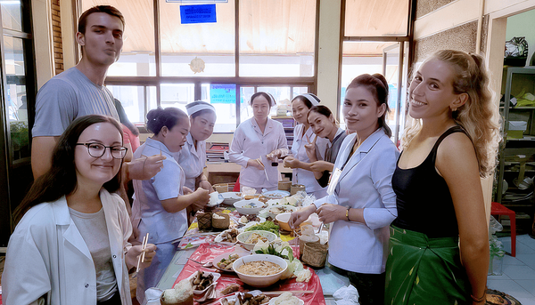 <p>Un dîner typique du Département de médecine interne du Lux Maria Teresa Hospital avec, au premier plan, Karolanne Demers, à droite, et deux de ses collègues stagiaires. Chaque midi, une infirmière est désignée pour cuisiner le repas à partir des différents aliments du jardin ou du marché apportés par les infirmières et médecins. Durant le stage, à tous les repas, les médecins comme les infirmières insistaient pour offrir à manger aux stagiaires. La nourriture était toujours extrêmement épicée.</p>