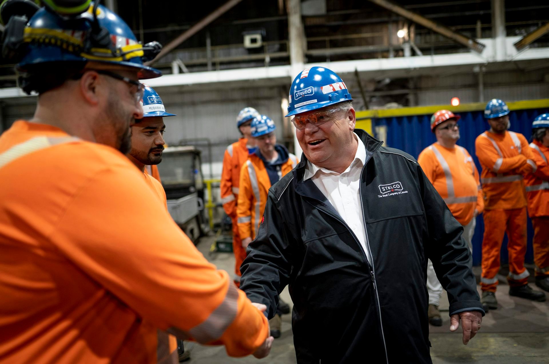 Le premier ministre de l'Ontario Doug Ford serre la main d'un ouvrier à l'aciérie de Stelco à Hamilton en Ontario, le 18 mai 2022.