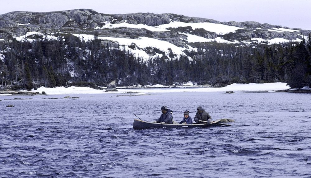 À bord d’un canot, les chasseurs William-Mathieu Mark (à l’arrière) et Joséphis, accompagnés d’un enfant, traversent le lac Coacoachou en mai 1982.