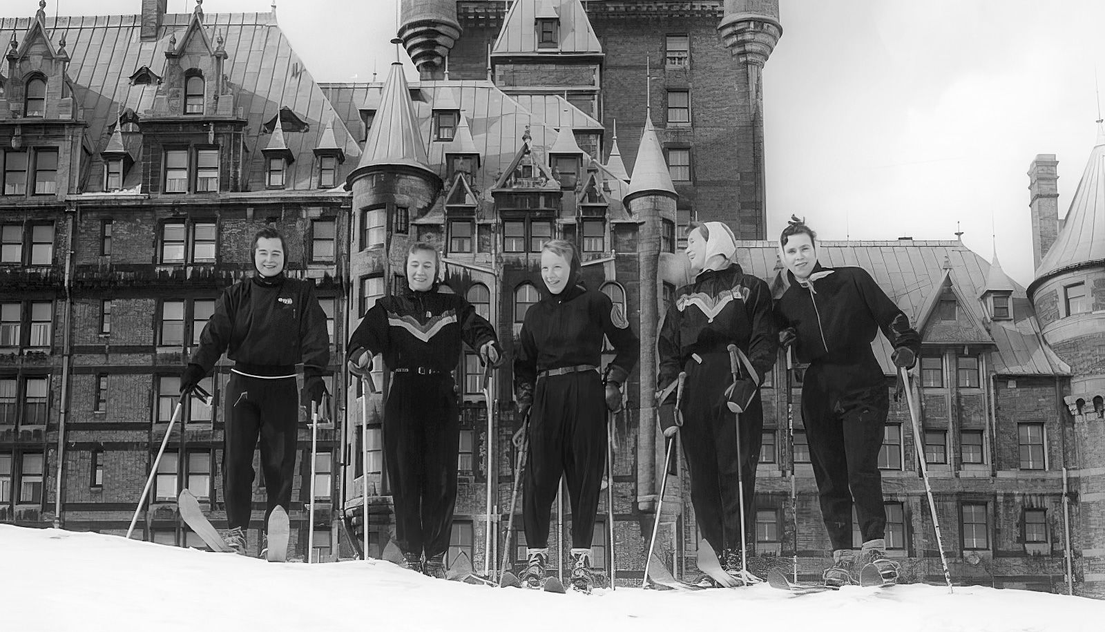 Des étudiantes en diététique de l’Université Laval adeptes du ski alpin posent fièrement devant le Château Frontenac durant l’hiver 1952. Parmi elles, les soeurs Jeannine et Jacqueline Pettigrew, respectivement deuxième et quatrième, font partie de l'équipe de ski alpin du Rouge et Or.