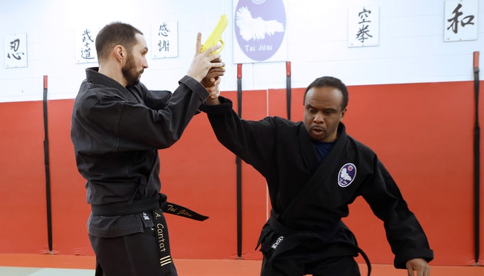 Le sensei Adrien Cantat du Club de jiu jitsu exécutant une technique de désarmement d'arme à feu sur le sensei Mohammed Afoundo. Ce dernier détient une maîtrise en traitement des eaux de l'Université Laval. L'un et l'autre donnent des cours au dojo du PEPS.