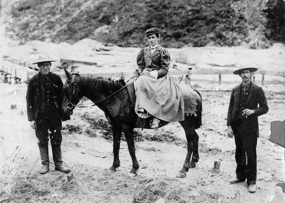 Madame Émilie Tremblay, en 1898, près du ruisseau Eldorado, au Yukon. Son neveu Edmond Tremblay se tient devant le cheval et Télesphore Simard, un Canadien-Français originaire de Baie-Saint-Paul, au Québec, est derrière.