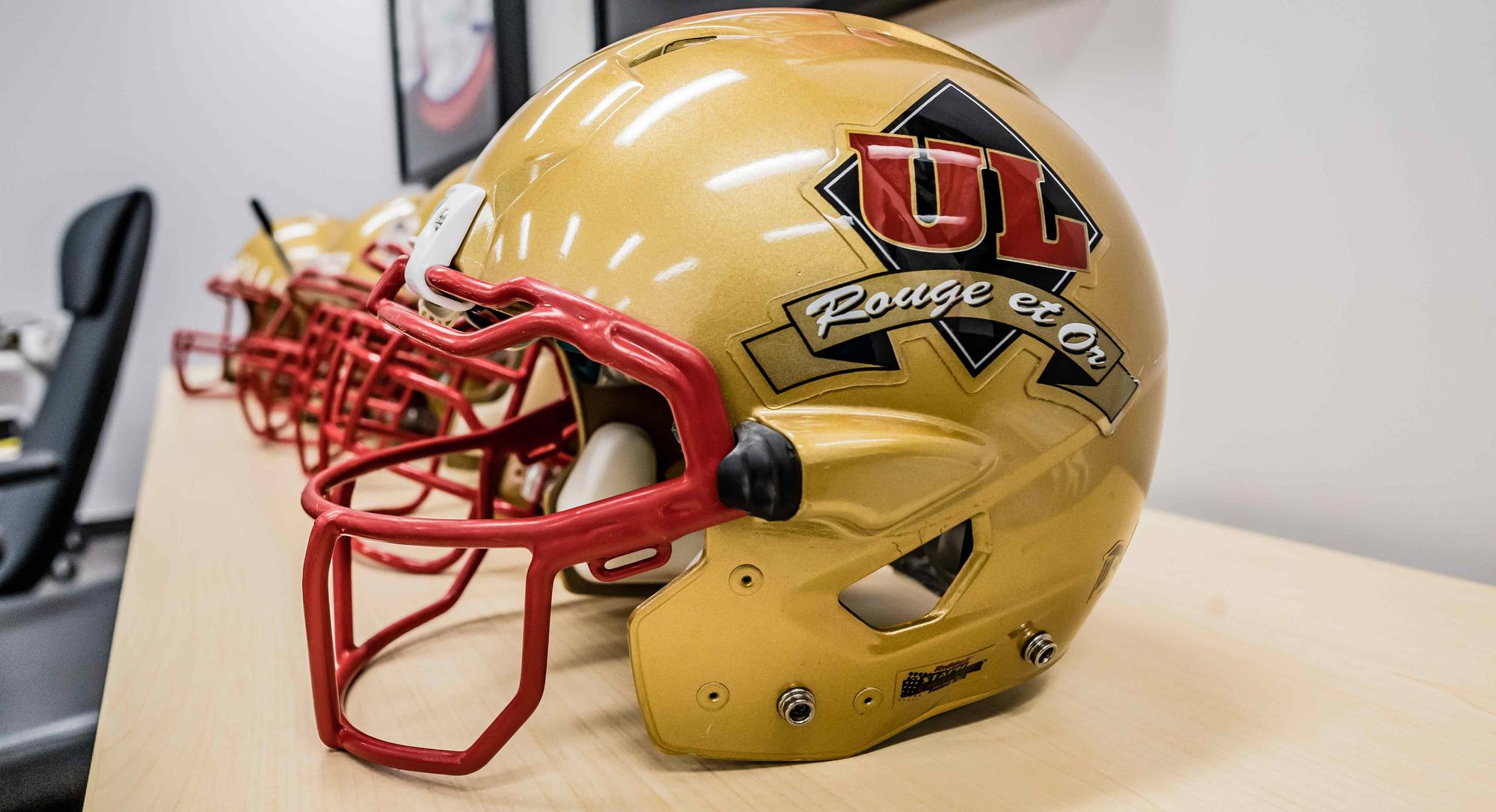 Des casques de football aux couleurs du club Rouge et Or de l'Université Laval.