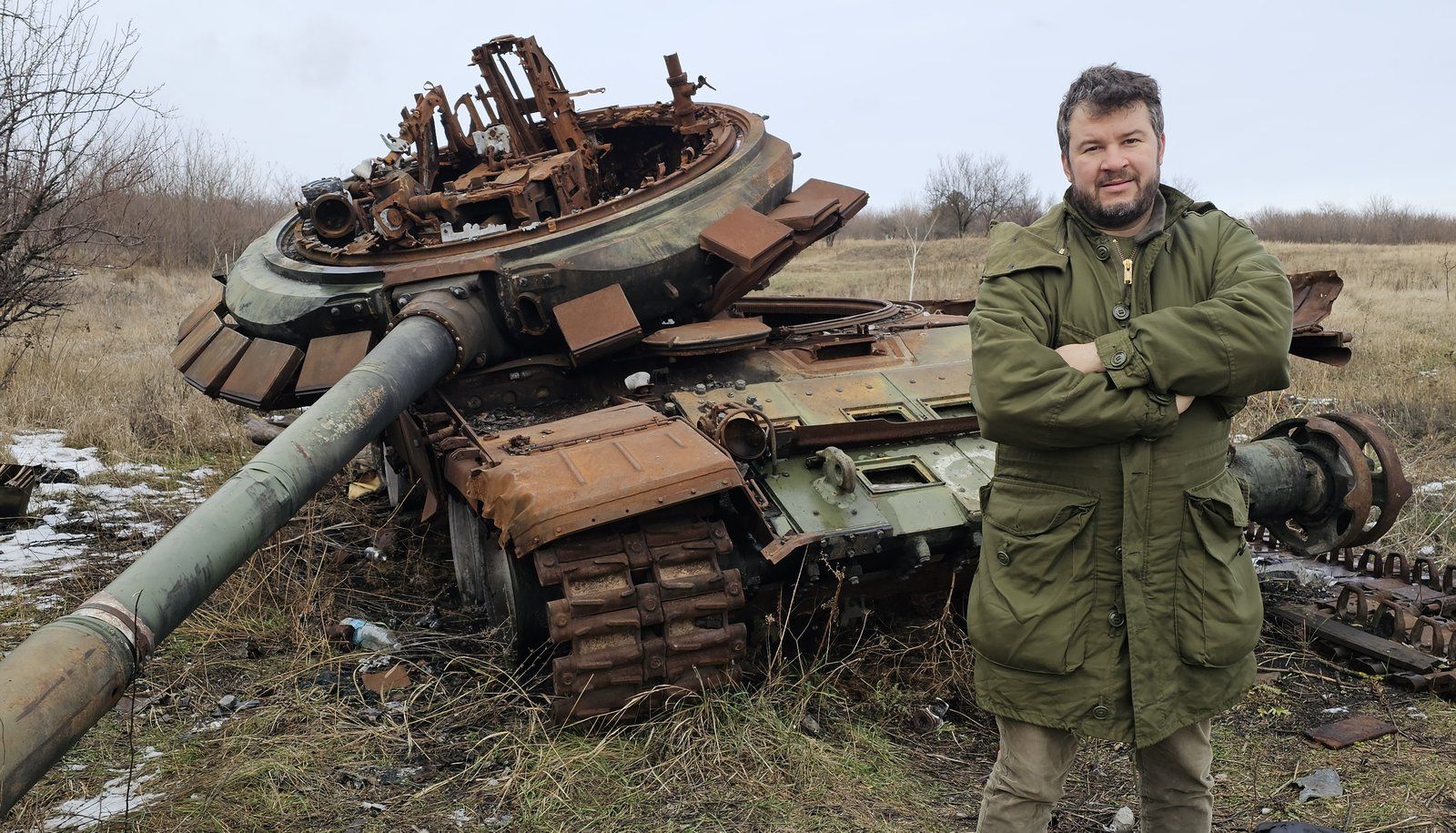 Jordan Proust devant l'épave d'un char russe T-72, détruit quelques mois plus tôt lors d'une contre-attaque ukrainienne.