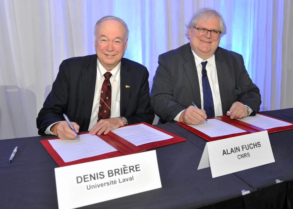 Le recteur de l'Université Laval, Denis Brière (à gauche), et le président du Centre national de la recherche scientifique, Alain Fuchs (à droite), signant les ententes de collaboration.