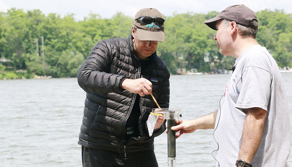 <p>Sur le quai du lac Saint-Augustin, les professeurs Reinhard Pienitz et Dermot Antoniades procèdent à l’extraction d’une carotte de sédiments.</p>