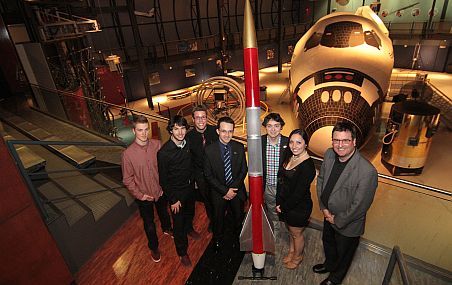 <p>La fusée Phénix a été présentée au grand public, au Cosmodôme de la ville de Laval, le 29 mai. Dans l'ordre, les étudiants Dominic Caron, Jonathan Neault, Julien Guay, Marc-André Gélinas, Olivier Lacroix et Andréa Matte, ainsi que Sylvain Bélair, directeur général du Cosmodôme. À l'arrière: une réplique approximative de la section avant d'une navette spatiale américaine servant comme simulateur au camp spatial du Cosmodôme.</p>