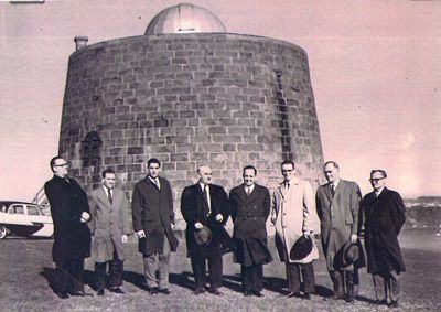 Huit membres de la Société royale d'astronomie du Canada ? centre Québecposent devant la tour Martello numéro un qui a abrité un observatoire de1941 à 1962.