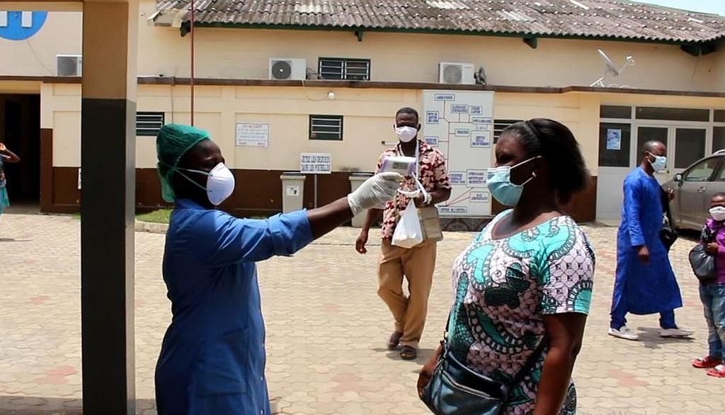 <p>Une femme se fait prendre sa température avec un thermomètre électronique dans un hôpital du Togo. Les personnes testées positives au coronavirus font fréquemment de la fièvre.</p>